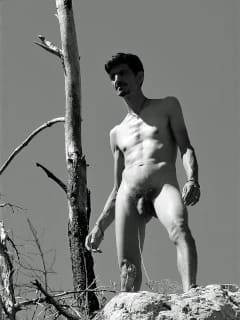 Mann auf einem Felsen stehend als künstlerische Männerakt-Aufnahme