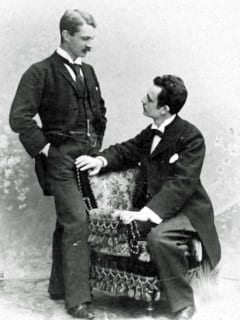 zwei Männer im Salon, einer stehend, einer sitzend